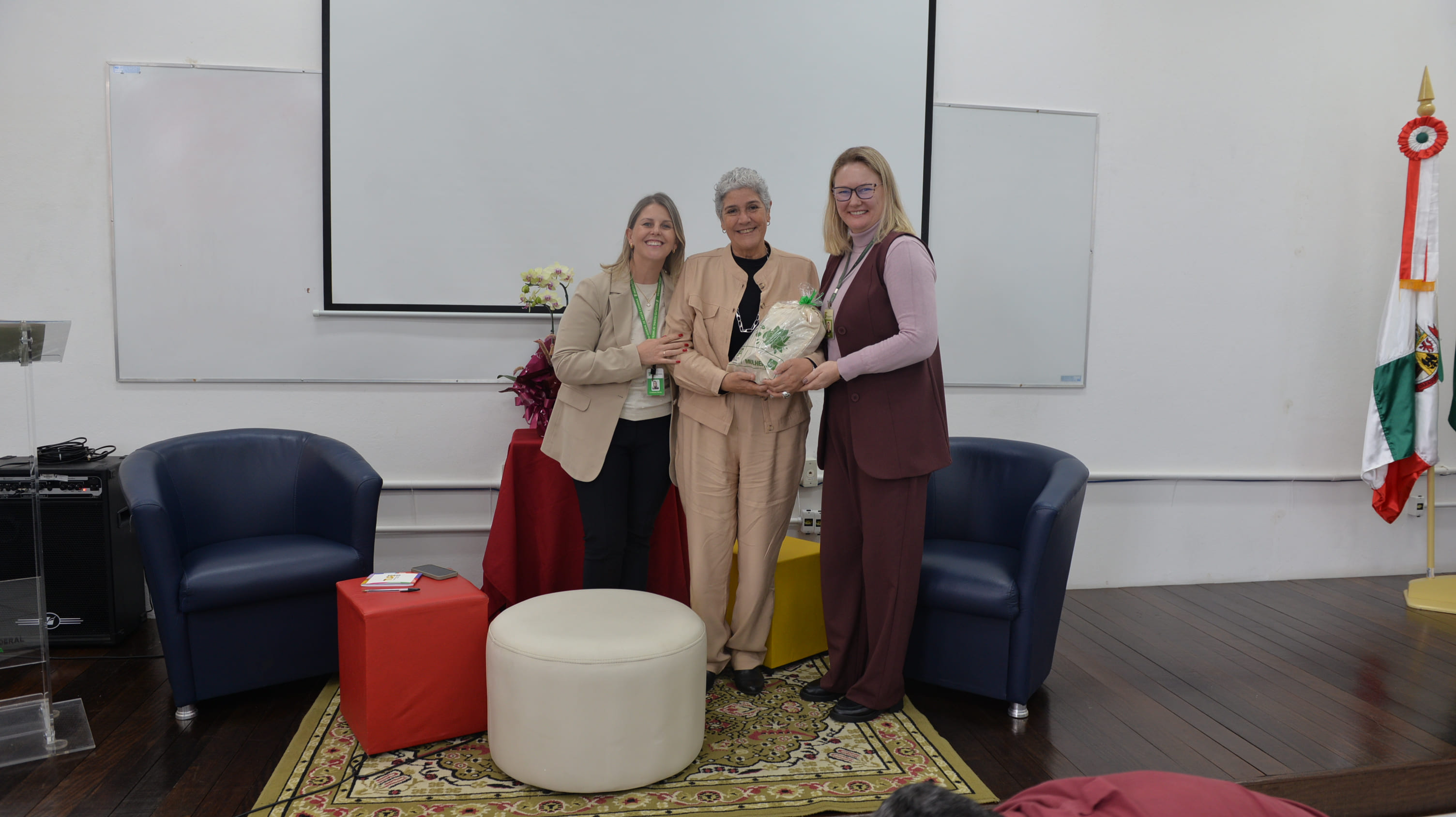 Professora Maria Carmen Silveira Barbosa (convidada, ao centro) é homenageada após a aula inaugural.
